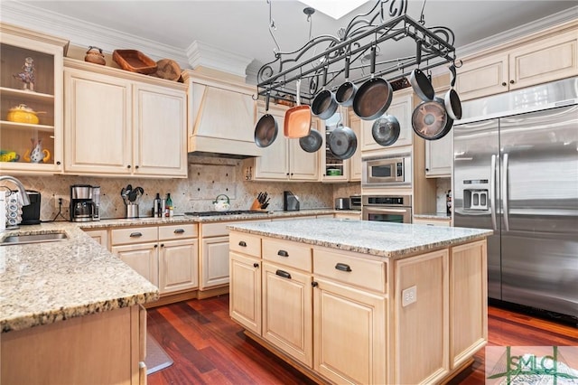 kitchen with crown molding, custom exhaust hood, backsplash, a sink, and built in appliances