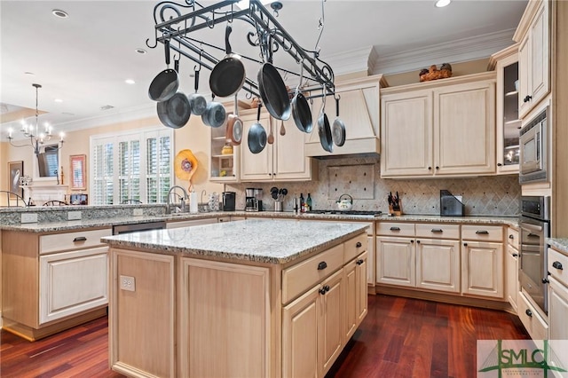 kitchen featuring stainless steel appliances, a peninsula, a center island, tasteful backsplash, and crown molding