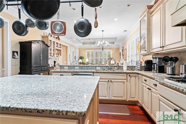 kitchen with a peninsula, crown molding, and a sink