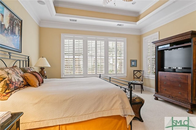 carpeted bedroom with a tray ceiling, visible vents, and crown molding