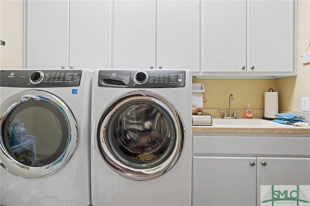 laundry room featuring cabinet space, a sink, and washing machine and clothes dryer