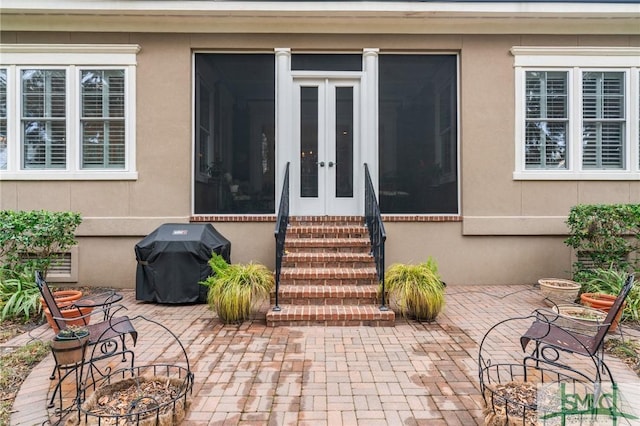 doorway to property featuring stucco siding, french doors, and a patio