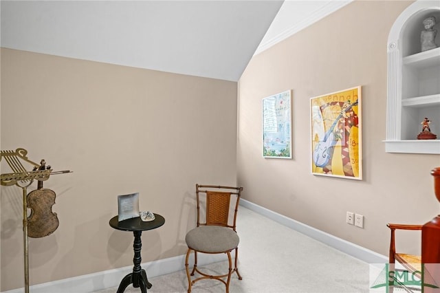 living area featuring lofted ceiling, baseboards, built in shelves, and carpet floors