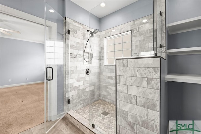 bathroom featuring ceiling fan, a shower stall, and baseboards