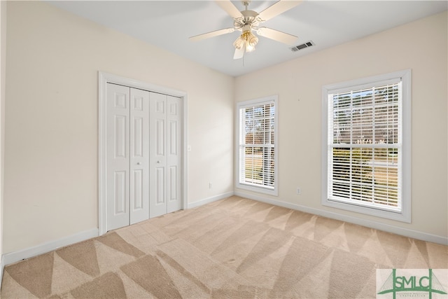 unfurnished bedroom with baseboards, visible vents, and light colored carpet