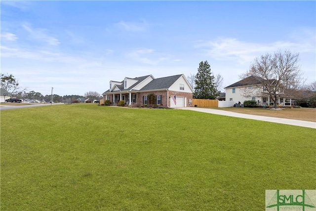 view of front of home featuring driveway, a front lawn, an attached garage, and fence