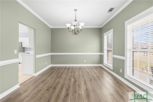 unfurnished room with ornamental molding, light wood-type flooring, visible vents, and baseboards