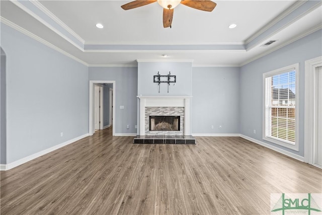 unfurnished living room with ornamental molding, a raised ceiling, and visible vents