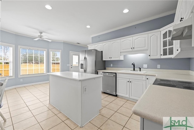 kitchen with a kitchen island, white cabinets, light countertops, appliances with stainless steel finishes, and glass insert cabinets