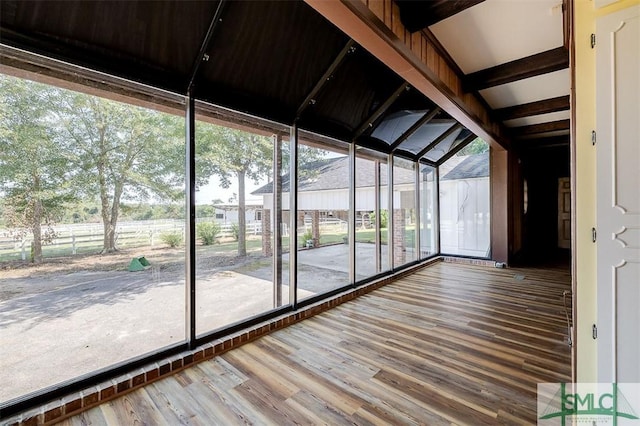 unfurnished sunroom featuring beam ceiling