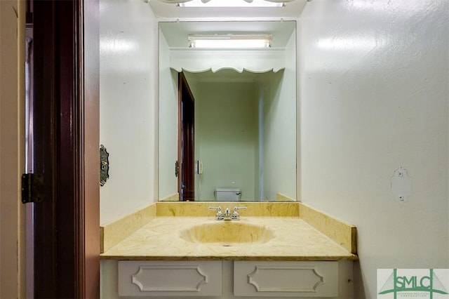 bathroom featuring vanity and toilet