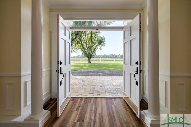 entryway with ornamental molding and dark wood finished floors