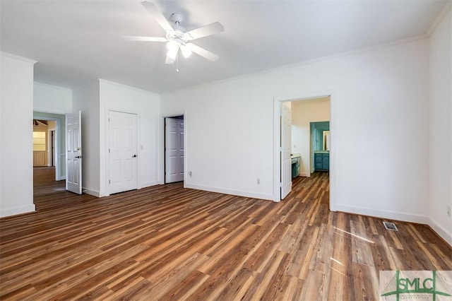 unfurnished bedroom featuring dark wood-style floors, visible vents, ornamental molding, and baseboards