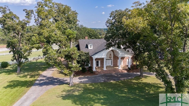 view of front of house featuring driveway, brick siding, and a front lawn