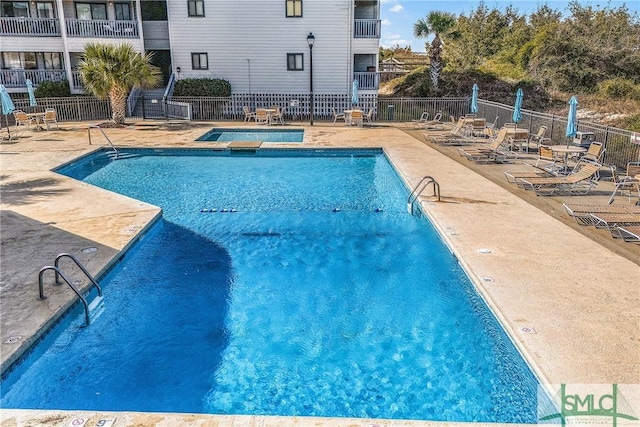 pool with a patio and fence