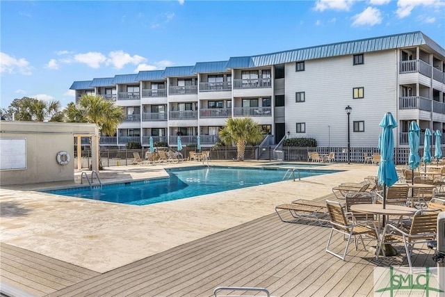 pool with a patio area and fence