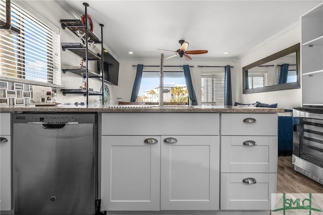 kitchen with plenty of natural light, crown molding, white cabinets, and stainless steel dishwasher