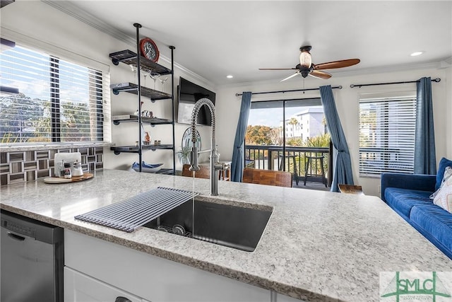 kitchen featuring a ceiling fan, dishwasher, light stone counters, crown molding, and a sink