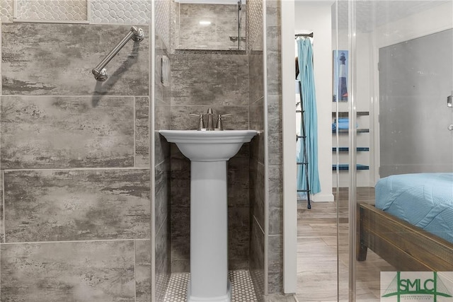 bathroom with a stall shower and tile walls