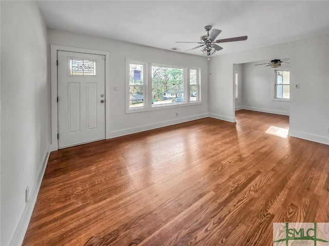 foyer entrance with visible vents, ceiling fan, baseboards, and wood finished floors