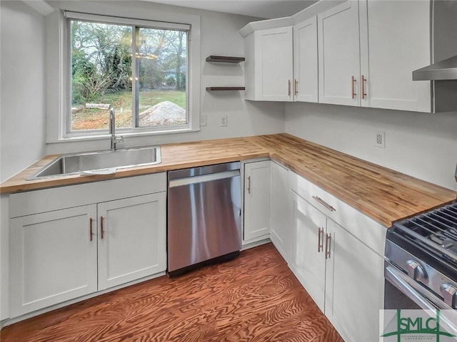 kitchen featuring butcher block countertops, appliances with stainless steel finishes, white cabinetry, open shelves, and a sink