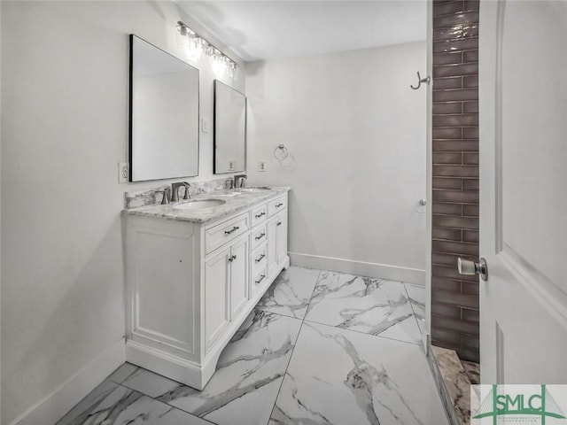 bathroom featuring marble finish floor, baseboards, and a sink