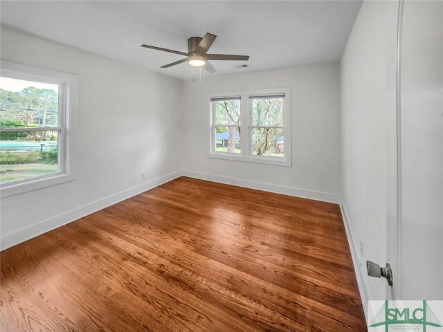 unfurnished room featuring visible vents, ceiling fan, baseboards, and wood finished floors