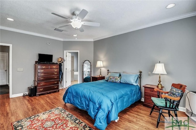 bedroom featuring crown molding, visible vents, baseboards, and wood finished floors