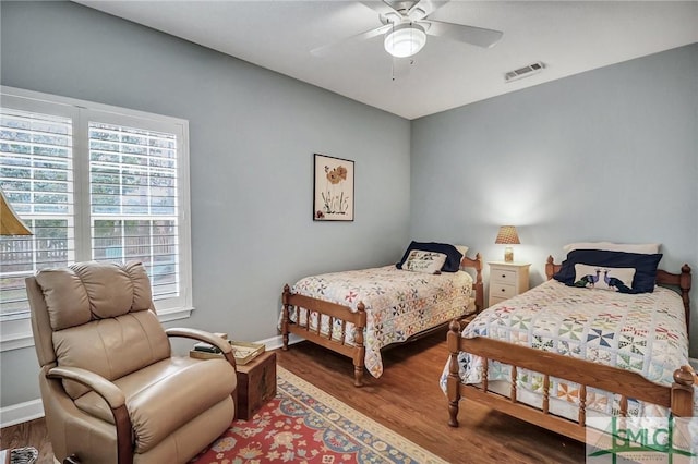 bedroom with visible vents, ceiling fan, baseboards, and wood finished floors