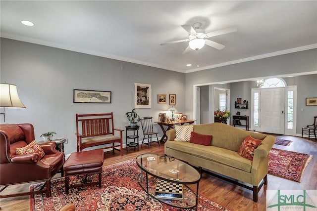 living room featuring ornamental molding, ceiling fan, and light wood finished floors