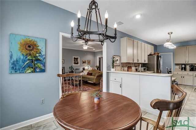 dining area with baseboards, light tile patterned flooring, and ceiling fan with notable chandelier