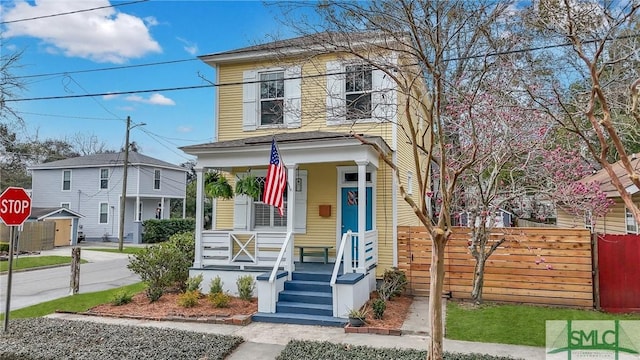 view of front facade featuring a porch and fence