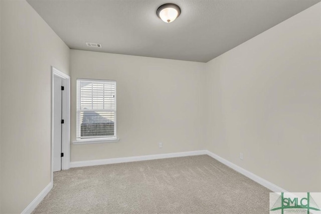 unfurnished room with light carpet, visible vents, and baseboards