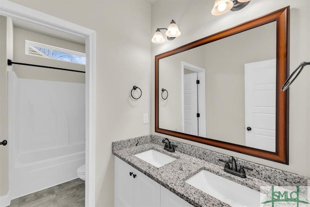 full bath with bathtub / shower combination, a sink, toilet, and double vanity