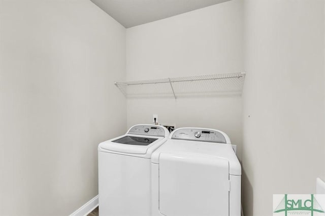 washroom with baseboards, laundry area, and washer and dryer