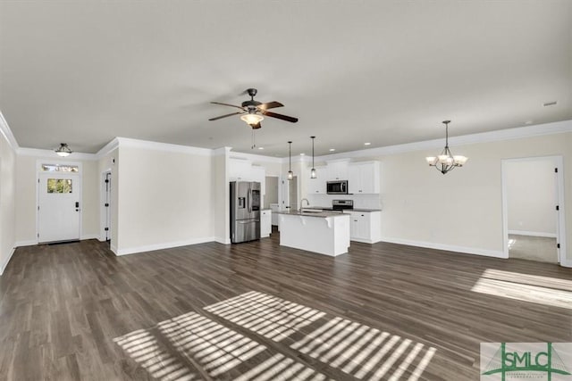 unfurnished living room with baseboards, dark wood-style floors, ornamental molding, a sink, and ceiling fan with notable chandelier