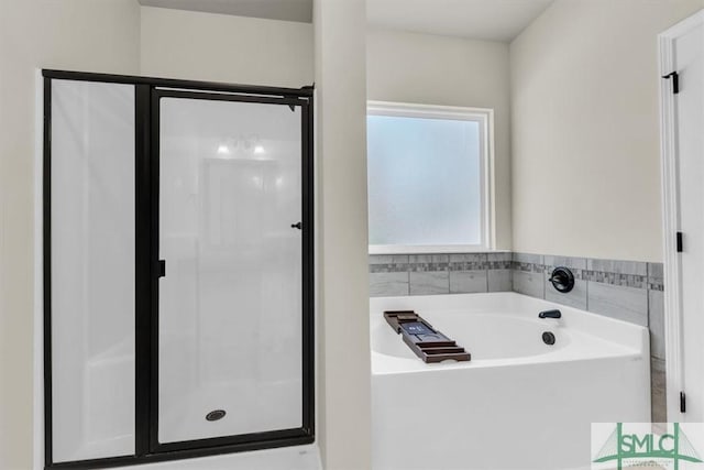 bathroom featuring a stall shower and a bath