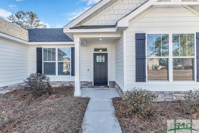 doorway to property featuring a shingled roof