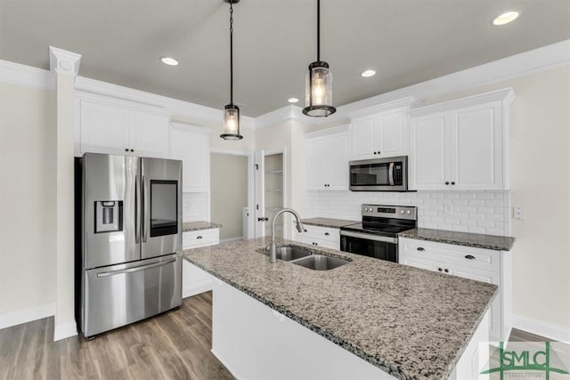 kitchen with light stone countertops, white cabinetry, appliances with stainless steel finishes, and pendant lighting