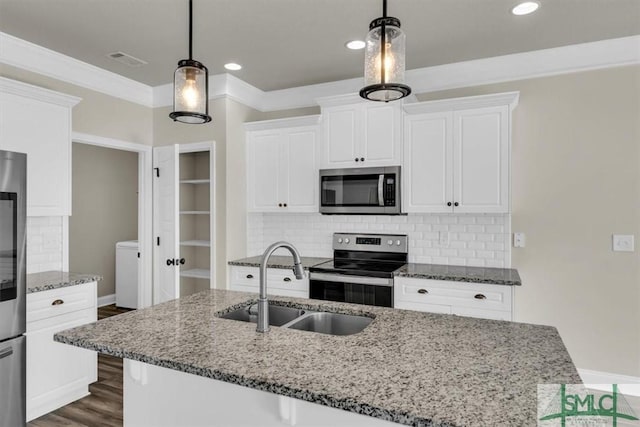 kitchen featuring hanging light fixtures, light stone counters, stainless steel appliances, and a sink