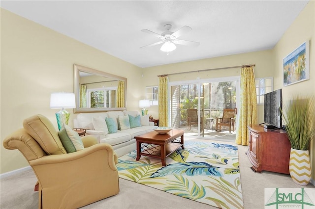 living area with light carpet, a ceiling fan, and a healthy amount of sunlight