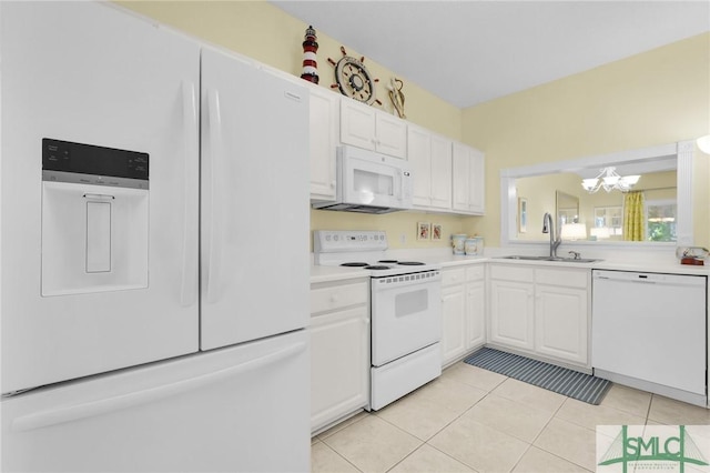 kitchen with white appliances, light tile patterned floors, white cabinets, light countertops, and a sink