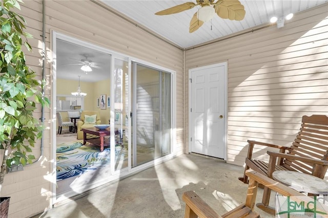 sunroom / solarium featuring ceiling fan with notable chandelier