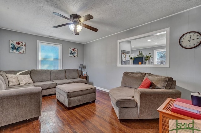 living room with plenty of natural light, a textured ceiling, and dark wood-style flooring