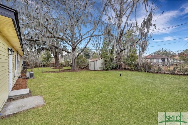 view of yard featuring a fenced backyard, an outdoor structure, central AC unit, and a shed