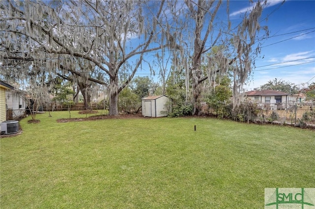 view of yard featuring a storage shed, an outbuilding, fence, and central air condition unit