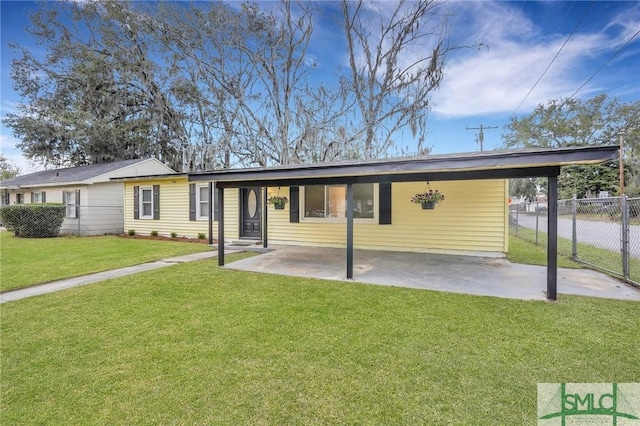 view of front facade with a carport, fence, and a front lawn