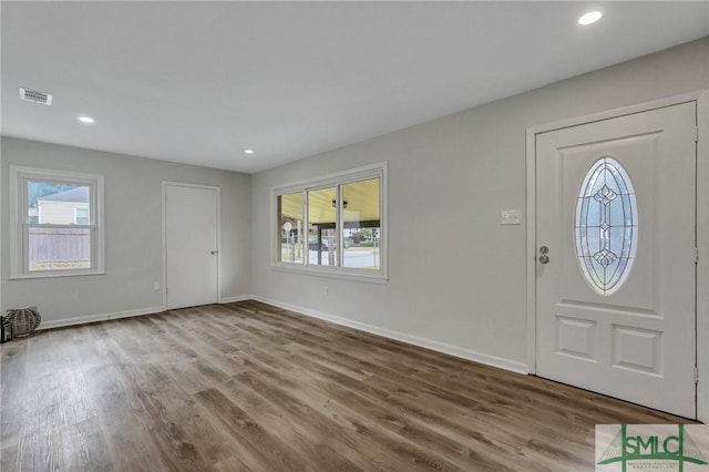 foyer with wood finished floors, visible vents, and baseboards