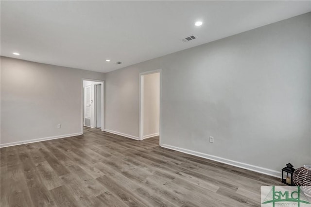 spare room with recessed lighting, visible vents, baseboards, and wood finished floors