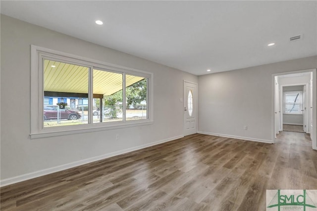 unfurnished living room featuring baseboards, visible vents, wood finished floors, and recessed lighting